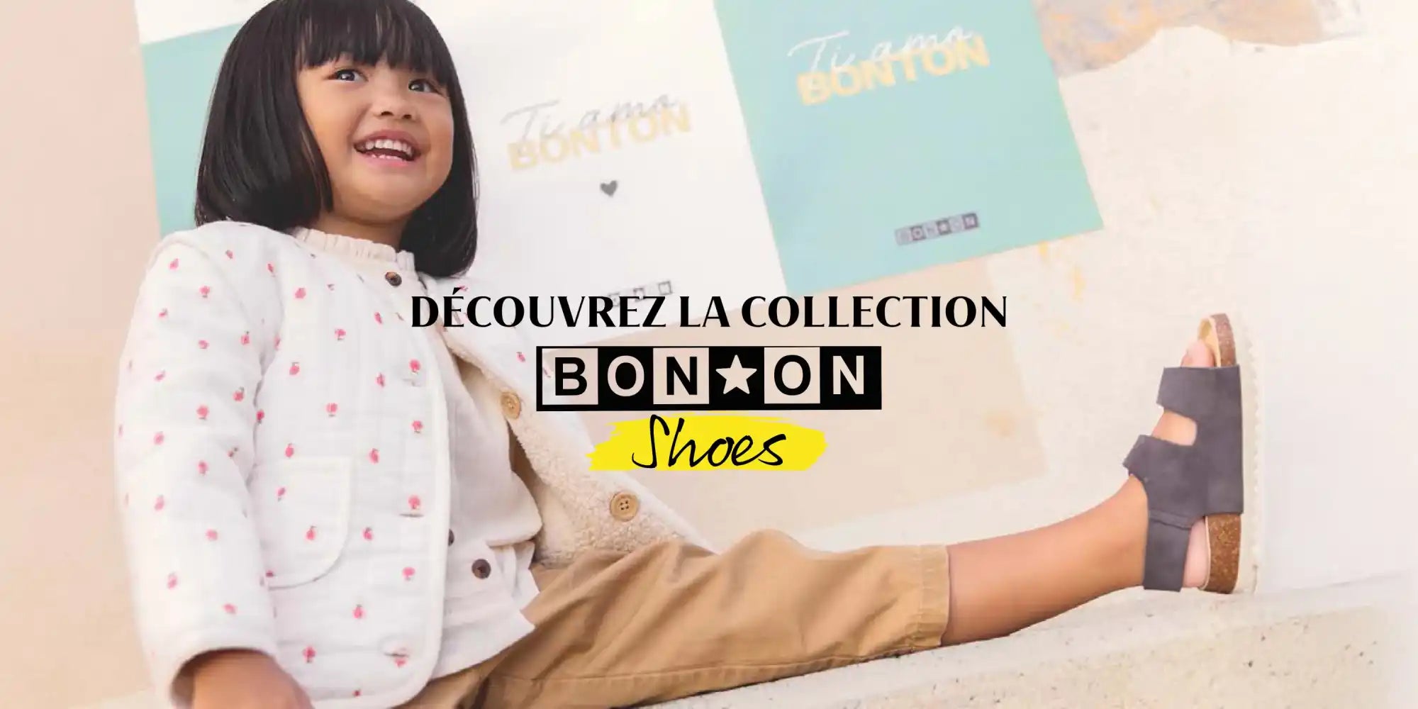 Une tenue confortable et élégante pour un jeune enfant, comprenant une veste légère à motif, un pantalon beige et des sandales foncées.
