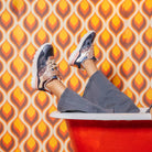 Une paire de baskets de couleur foncée avec des accents roses et dorés.