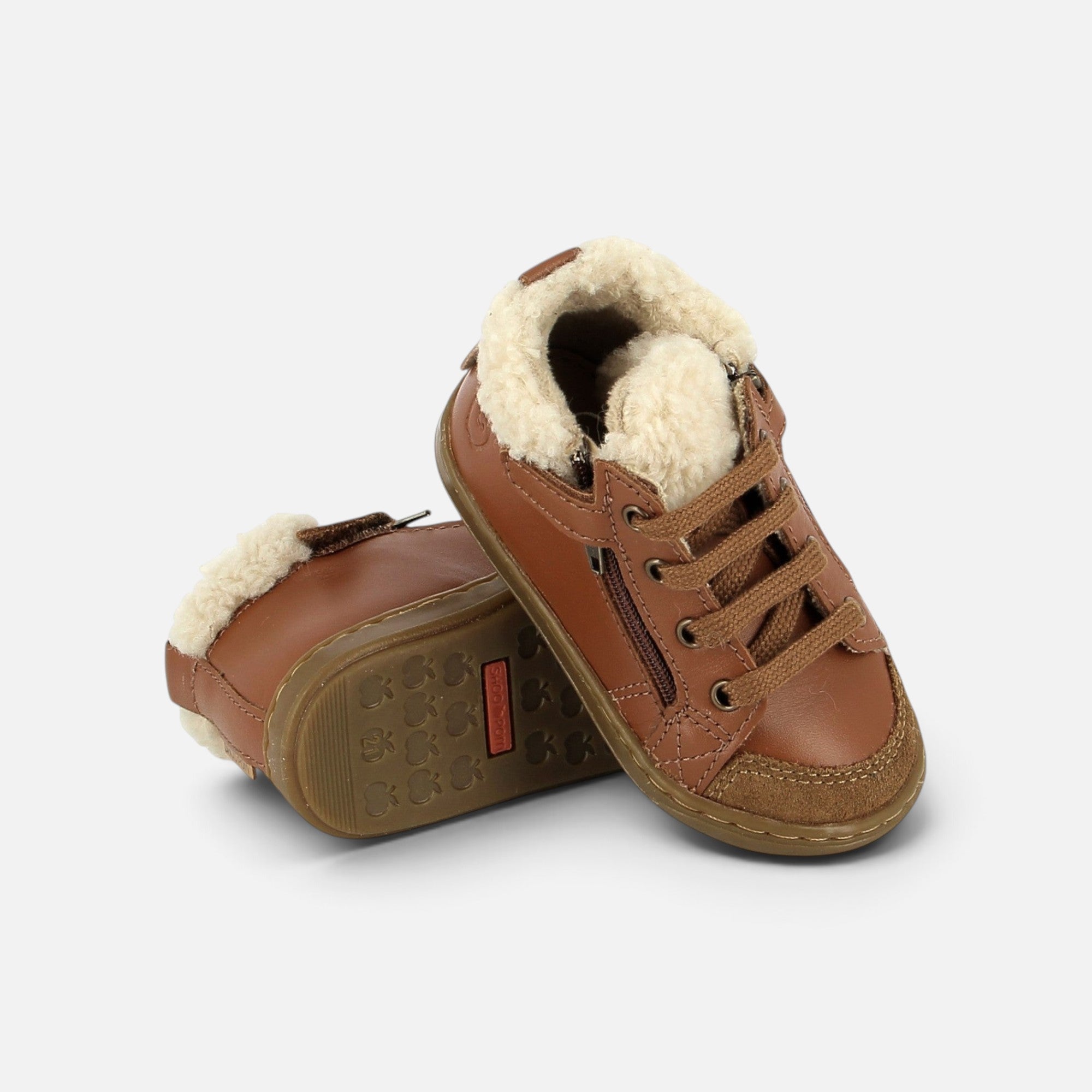 Chaussures premiers-pas Shoo Pom en cuir camel avec doublure en fourrure, lacets et fermeture éclair latérale.