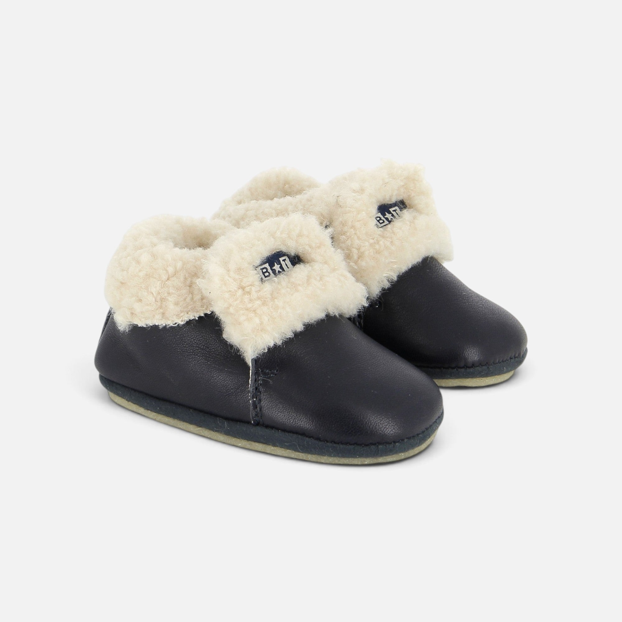 Chaussons bébé Shoo Pom en cuir bleu marine avec doublure en fourrure synthétique crème et logo sur le côté