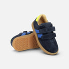 Baskets Shoo Pom Yuzu en velours bleu marine avec bandes bleues, scratchs et talon jaune sur semelle en gomme